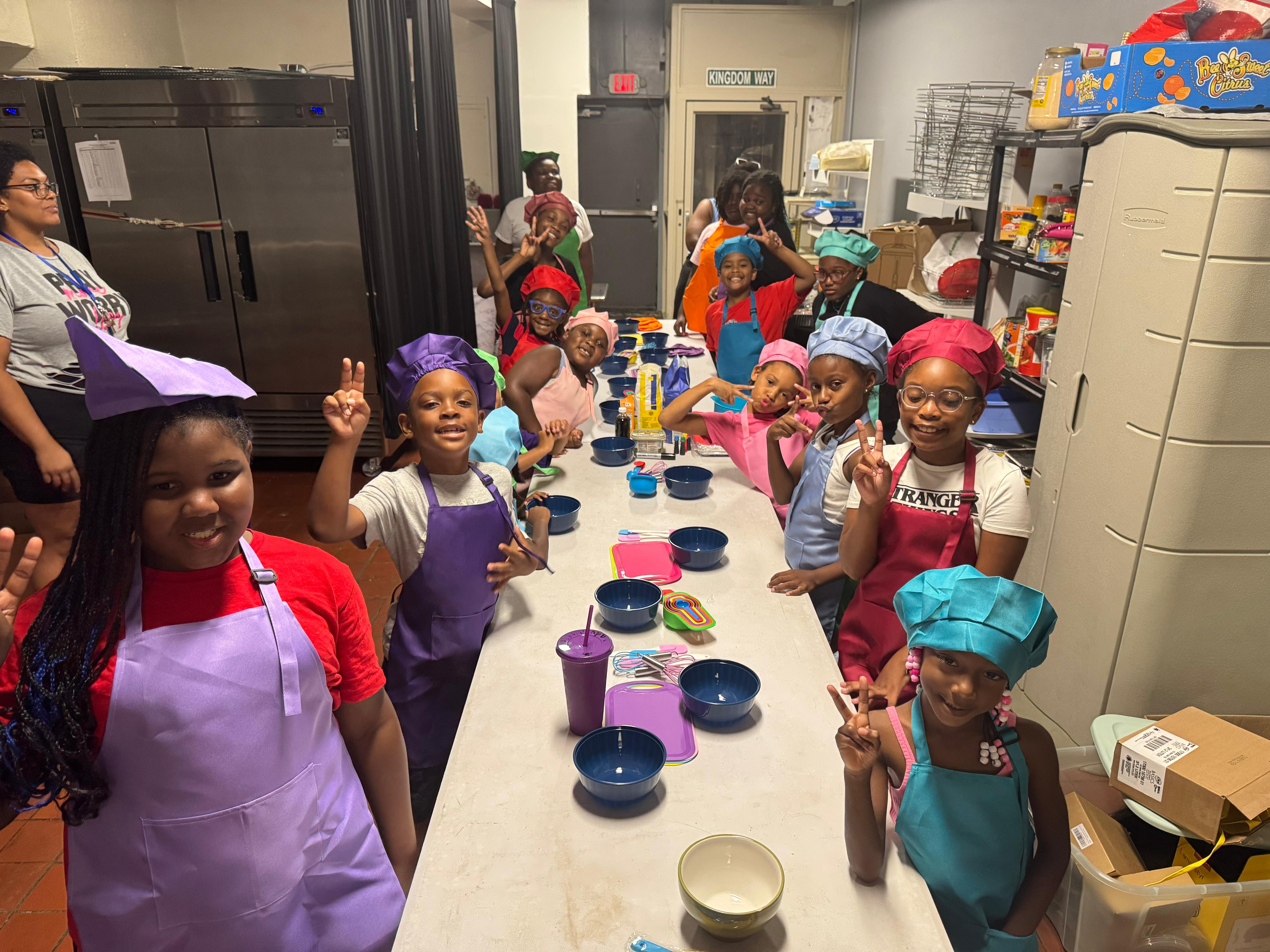 Junior chefs ready for cooking class in their aprons and chef hats