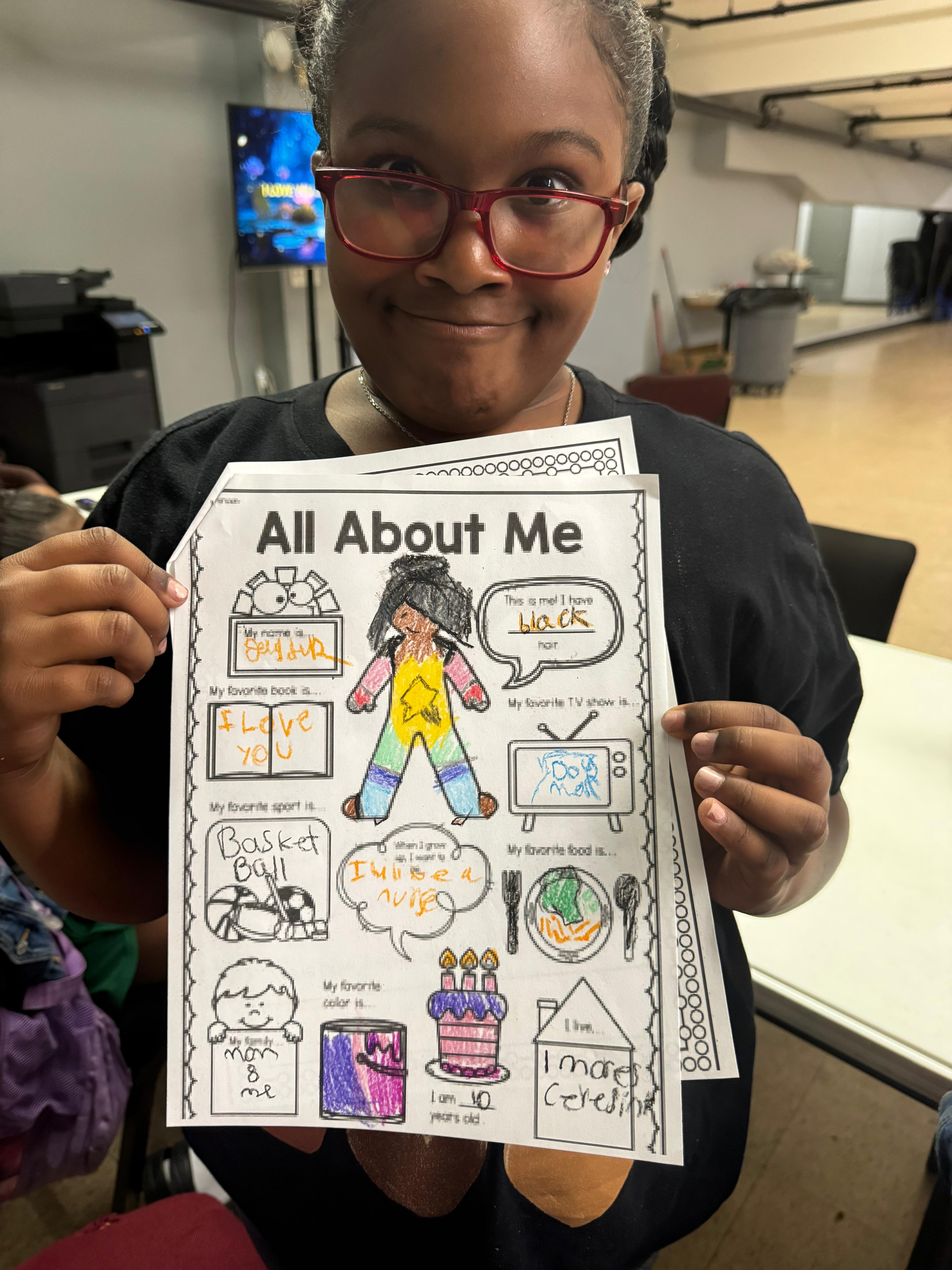 Proud camper shows off her completed 'All About Me' worksheet